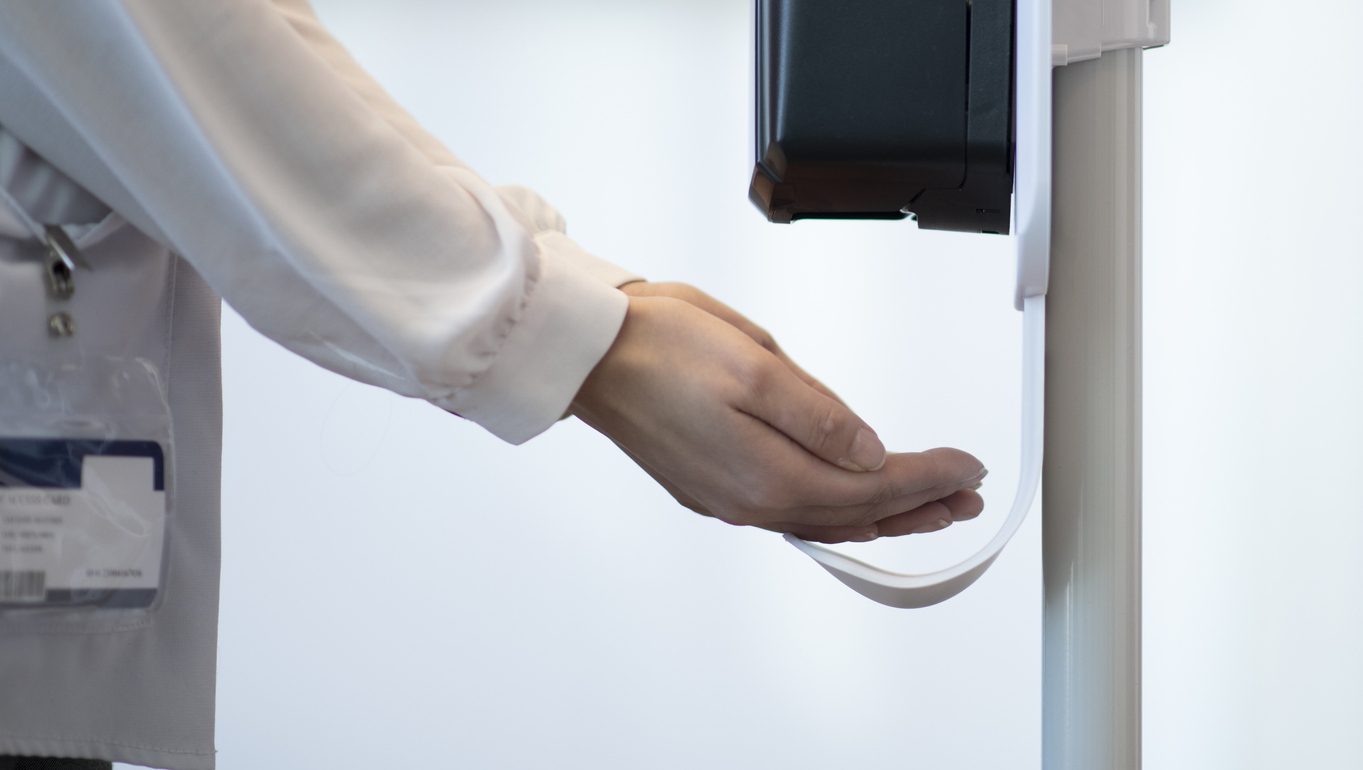 Medical Professional using a touchless sanitizer dispenser